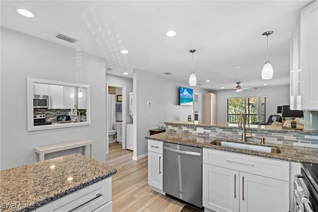 kitchen with sink, stainless steel appliances, hanging light fixtures, and white cabinets