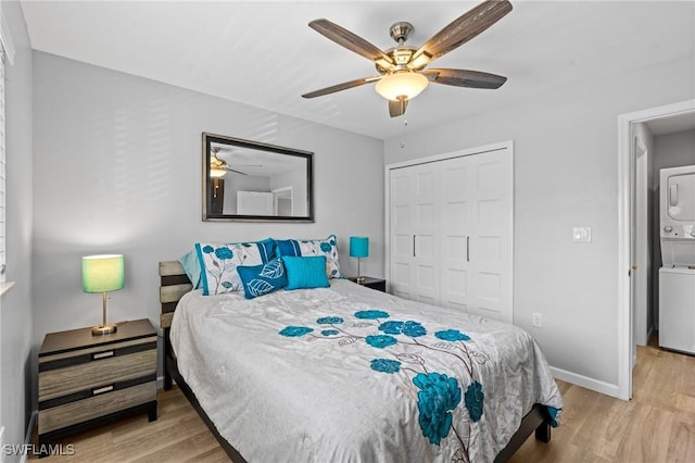 bedroom featuring a closet, stacked washer and clothes dryer, ceiling fan, and light wood-type flooring