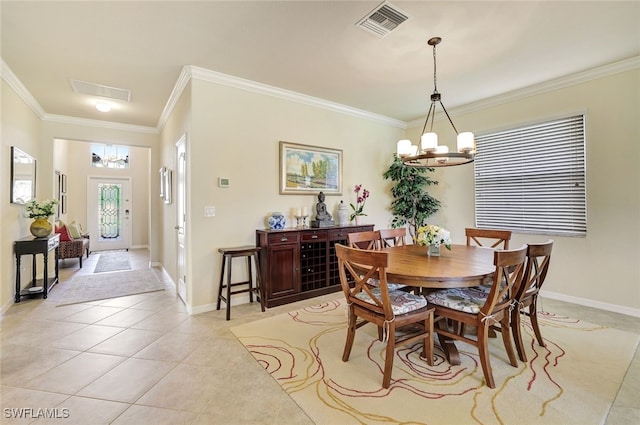 dining area featuring an inviting chandelier, light tile patterned floors, and ornamental molding