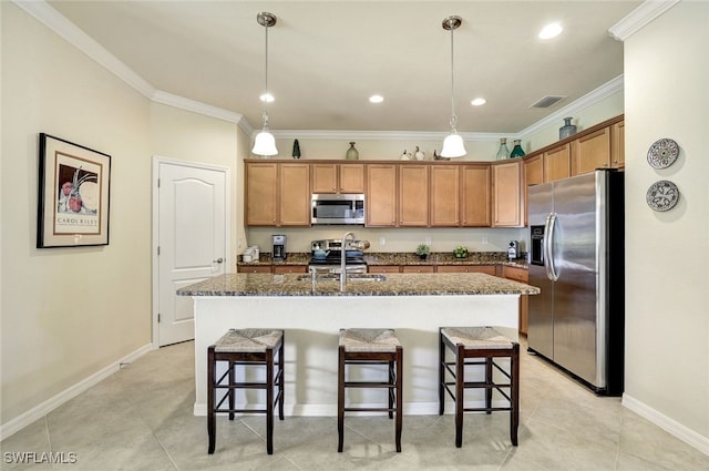 kitchen featuring decorative light fixtures, sink, ornamental molding, stainless steel appliances, and a center island with sink