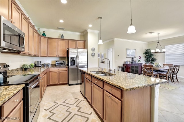 kitchen featuring sink, hanging light fixtures, ornamental molding, stainless steel appliances, and a kitchen island with sink