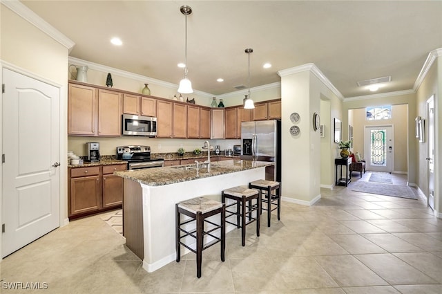 kitchen featuring sink, a breakfast bar area, a kitchen island with sink, dark stone countertops, and stainless steel appliances