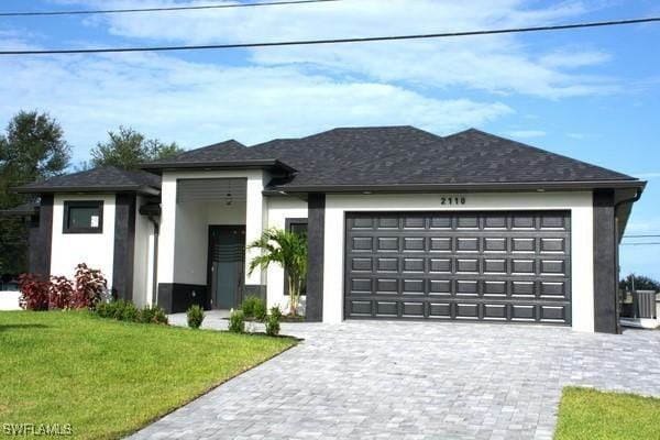 prairie-style home with a garage and a front lawn