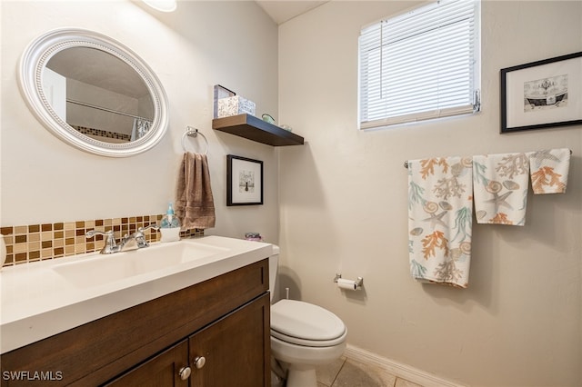 bathroom with tasteful backsplash, vanity, tile patterned flooring, and toilet