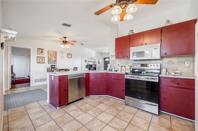 kitchen with tasteful backsplash, light tile patterned flooring, kitchen peninsula, and appliances with stainless steel finishes