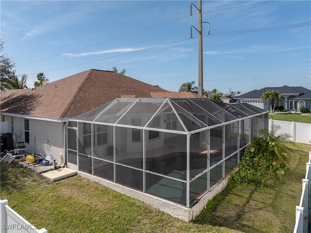 back of property with a fenced in pool, a lanai, and a yard