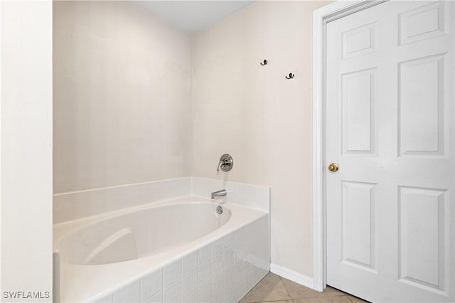 bathroom featuring a relaxing tiled tub and tile patterned flooring