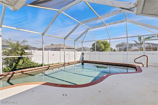 view of pool with glass enclosure and a patio area