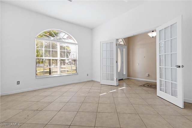 tiled empty room featuring french doors