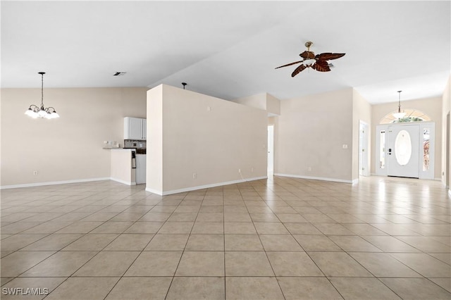 unfurnished living room with vaulted ceiling, ceiling fan with notable chandelier, and light tile patterned floors