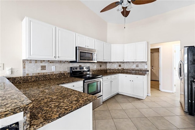 kitchen with white cabinetry, appliances with stainless steel finishes, dark stone countertops, and decorative backsplash