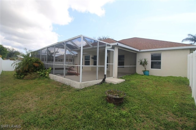 rear view of property with a lanai and a lawn