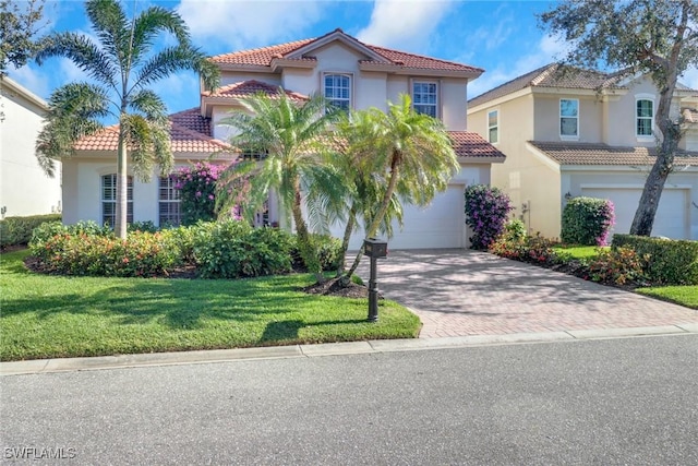 mediterranean / spanish-style home featuring a garage and a front lawn