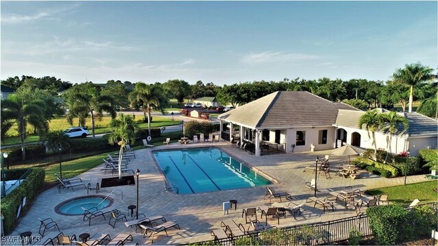 view of swimming pool featuring a hot tub and a patio area