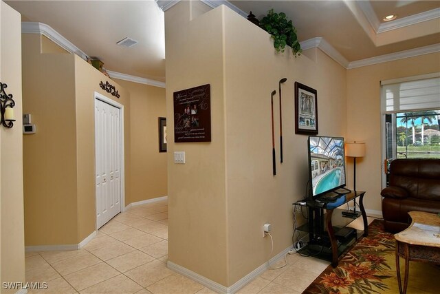 corridor with crown molding and light tile patterned floors