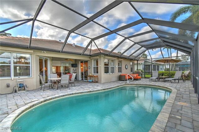 view of pool with a patio and glass enclosure