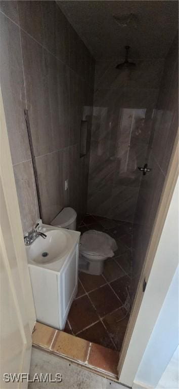 bathroom with vanity, tile walls, and toilet