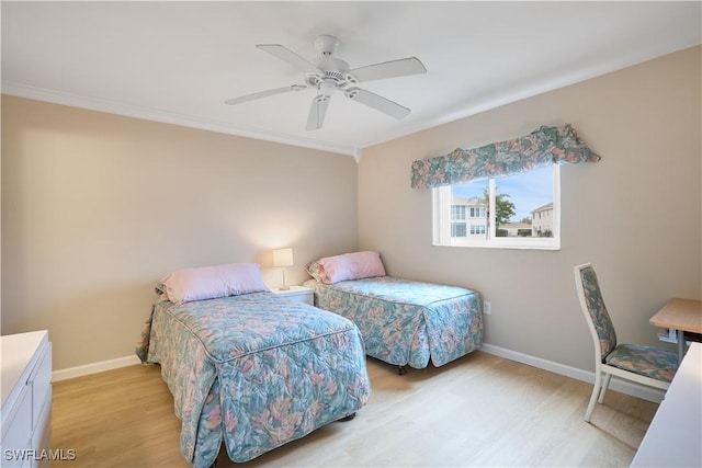 bedroom with crown molding, ceiling fan, and light wood-type flooring