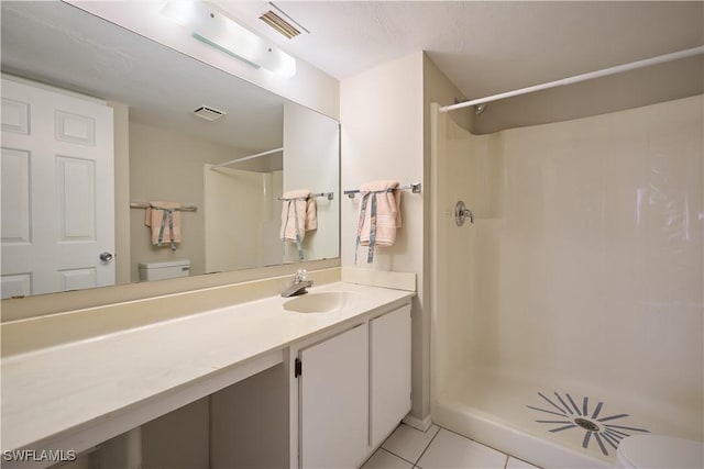 bathroom with walk in shower, vanity, toilet, and tile patterned flooring