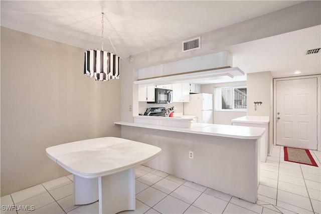 kitchen with a breakfast bar, white cabinetry, white refrigerator, kitchen peninsula, and stainless steel stove