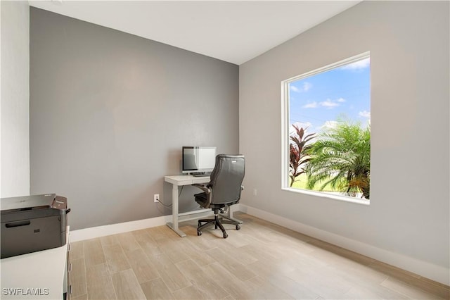 home office with light hardwood / wood-style floors