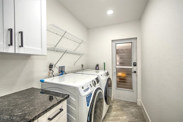 laundry area with washing machine and dryer and cabinets