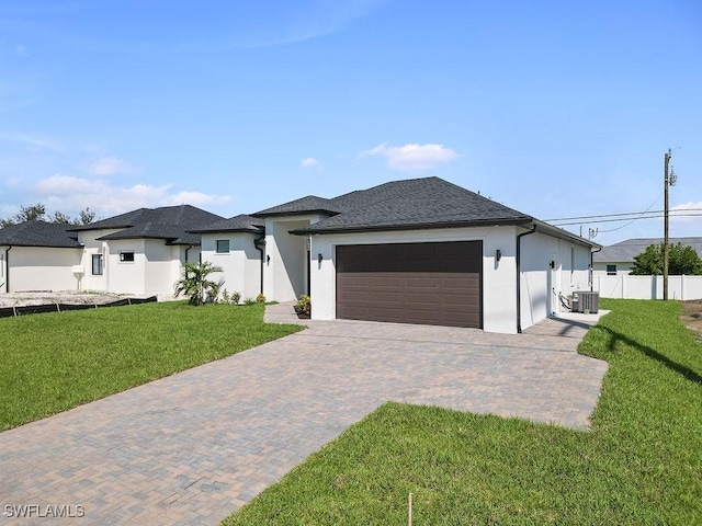 prairie-style home featuring central AC unit, a garage, and a front yard