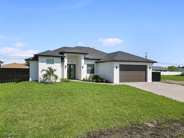 prairie-style house featuring a garage and a front lawn