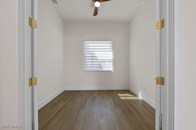 empty room with dark wood-type flooring and ceiling fan