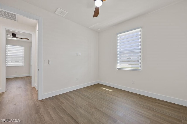 unfurnished room with a wealth of natural light, light hardwood / wood-style floors, and ceiling fan