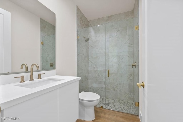 bathroom with vanity, hardwood / wood-style floors, toilet, and an enclosed shower