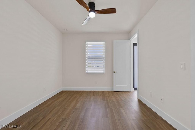 empty room with ceiling fan and dark hardwood / wood-style flooring