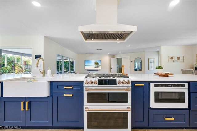 kitchen with blue cabinets, double oven range, oven, and island exhaust hood