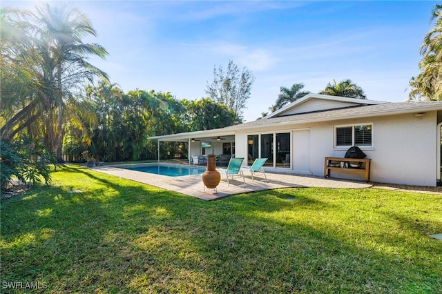 back of property with a patio area and a lawn