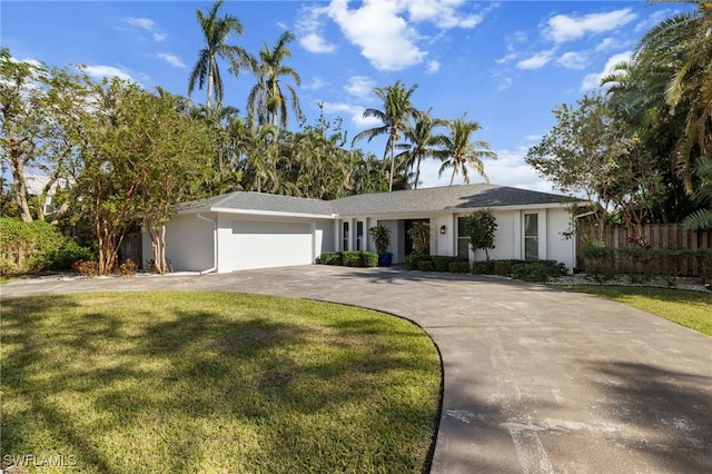 ranch-style house featuring a garage and a front lawn