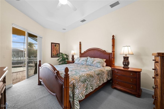 carpeted bedroom featuring a raised ceiling, access to outside, and ceiling fan