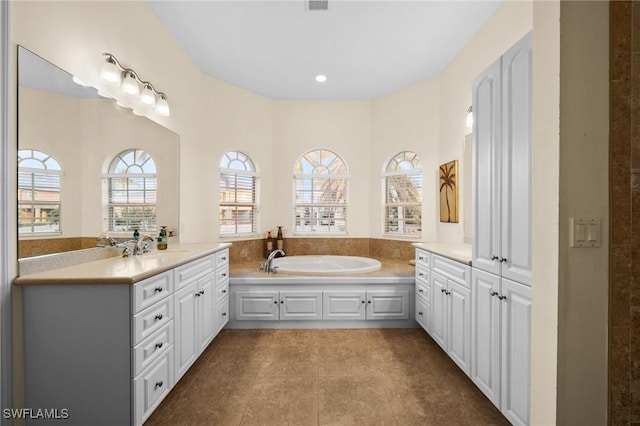 bathroom with vanity, a bath, and tile patterned floors