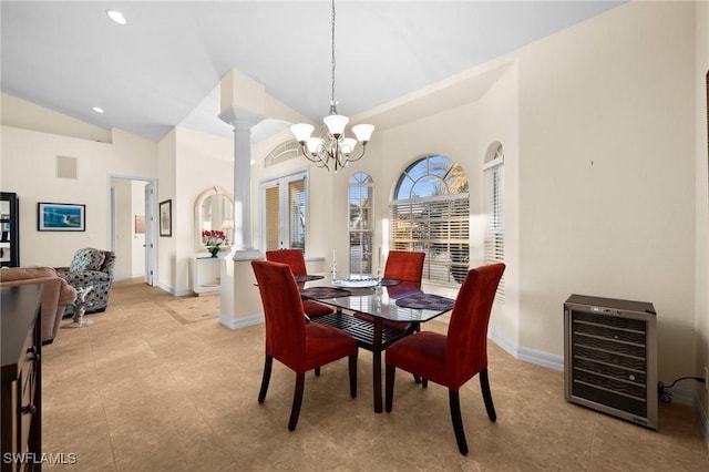 dining space with heating unit, decorative columns, lofted ceiling, a chandelier, and light tile patterned floors