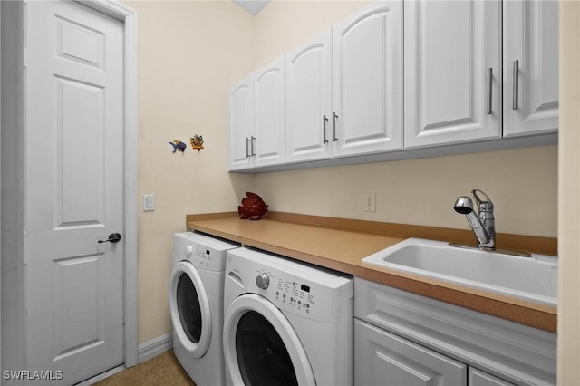 laundry area with cabinets, separate washer and dryer, and sink