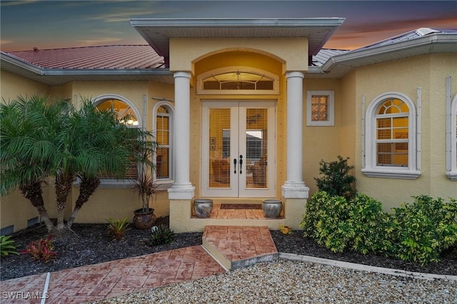 exterior entry at dusk featuring french doors