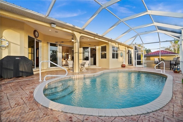 view of swimming pool featuring a lanai, area for grilling, ceiling fan, and a patio area