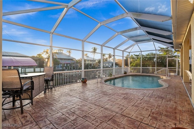 view of pool with a bar, a lanai, and a patio