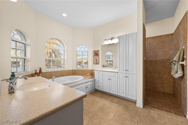 bathroom with tile patterned flooring, vanity, and separate shower and tub