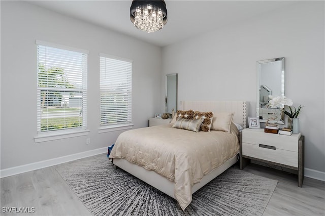 bedroom featuring wood-type flooring and a chandelier