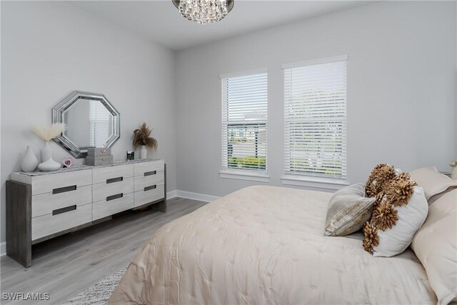 bedroom featuring hardwood / wood-style flooring and a chandelier