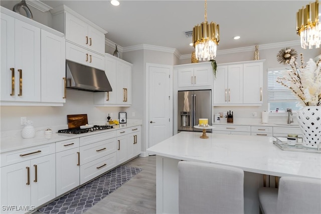 kitchen featuring pendant lighting, high end refrigerator, and white cabinets