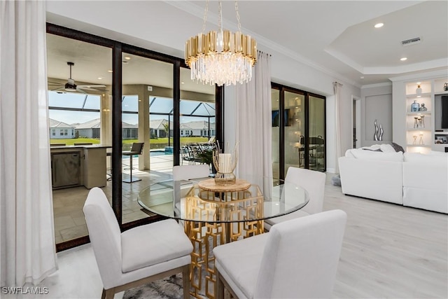 dining space with crown molding, light hardwood / wood-style floors, and ceiling fan with notable chandelier