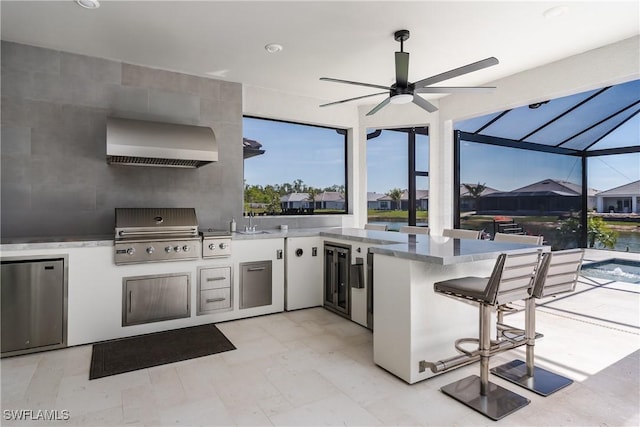 view of patio featuring a grill, sink, glass enclosure, and an outdoor kitchen