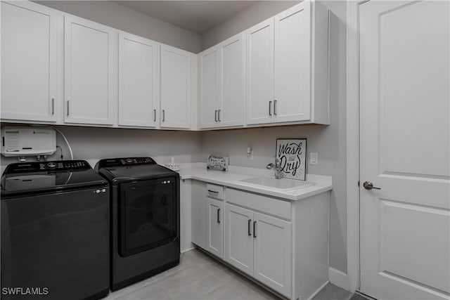 washroom with cabinets, sink, and washing machine and clothes dryer