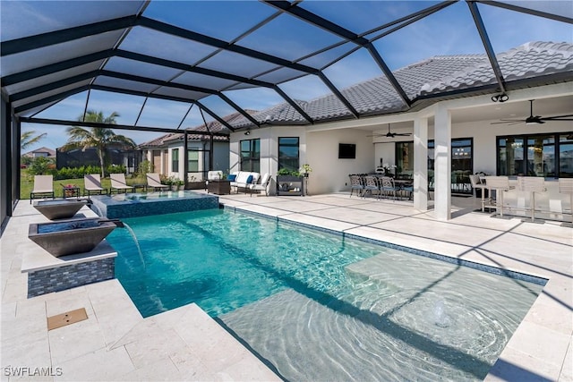 view of swimming pool with ceiling fan, a patio, glass enclosure, pool water feature, and exterior bar